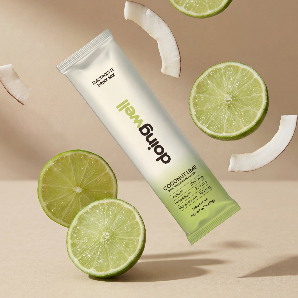 DoingWell Coconut Lime stick pack floating against a warm tan background, surrounded by fresh lime slices and white coconut pieces creating a dynamic, refreshing composition