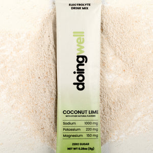 doing well electrolyte drink mix packet with coconut lime flavor on a light background