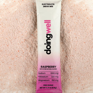 doing well electrolyte drink mix packet on a pinkish background