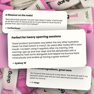 Pink and white electrolyte packets with customer reviews on a pink background