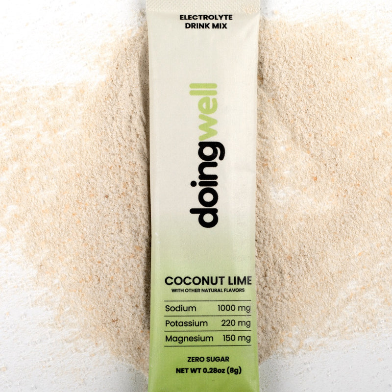 doing well electrolyte drink mix packet with coconut lime flavor on a white background